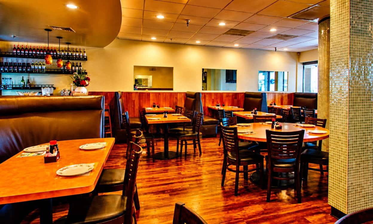 Golden Dragon dining room with booths, wood floors, and set tables